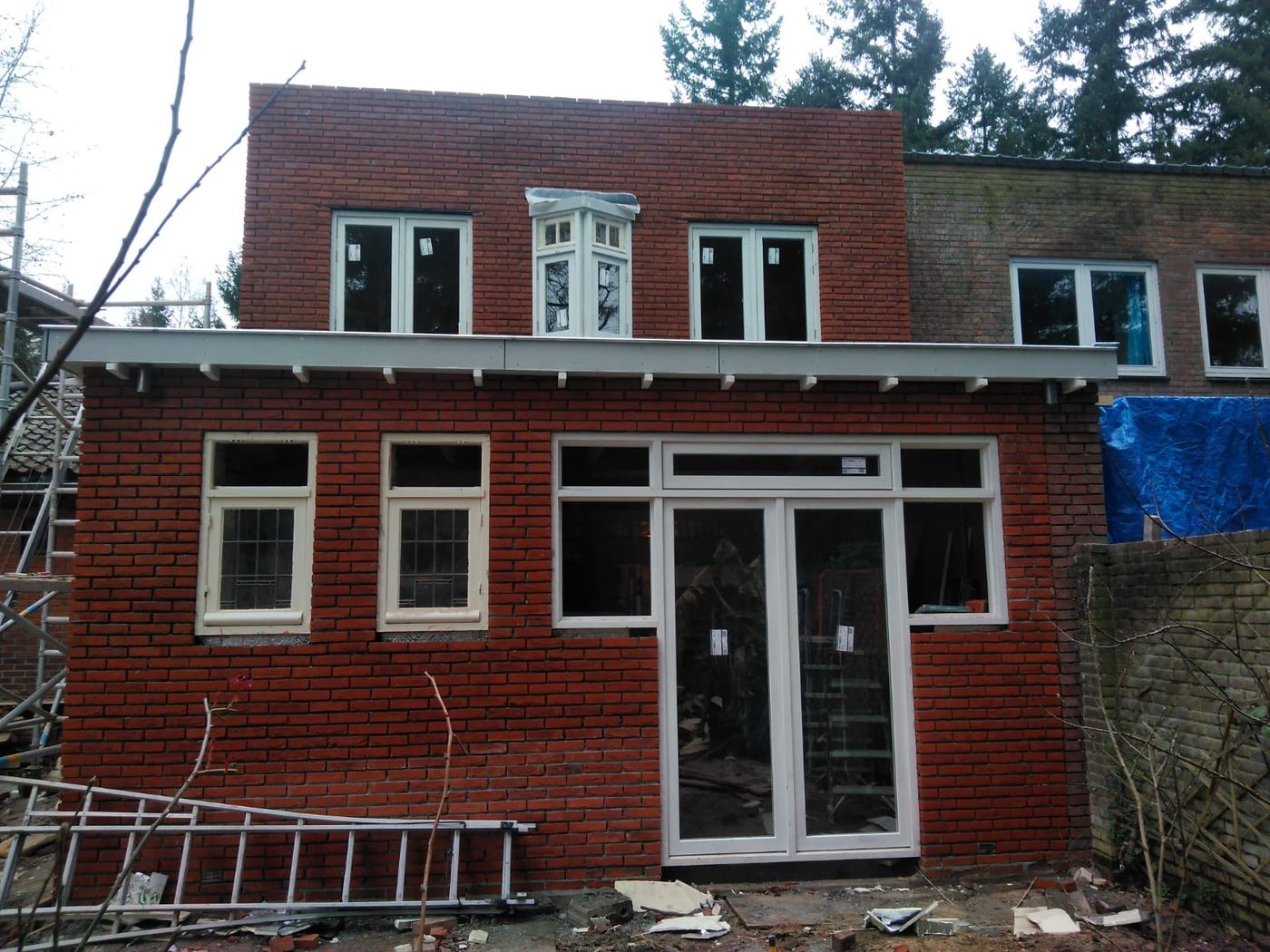 Afgeronde aanbouw in rode baksteen met nieuwe witte kozijnen